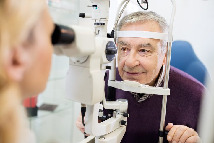 Young female eye specialist determines distance of eyes pupils to patient